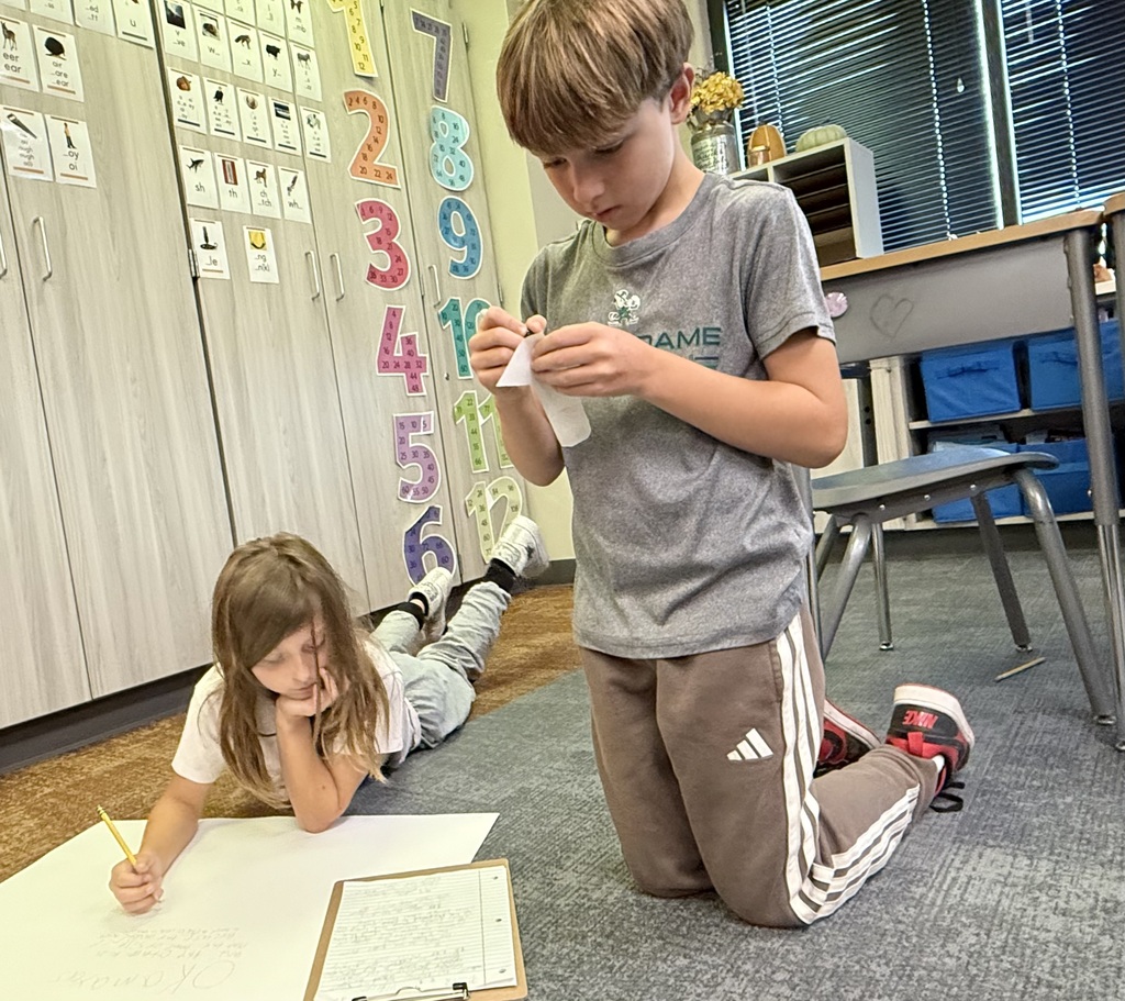 two students studying together on the floor in a classroom