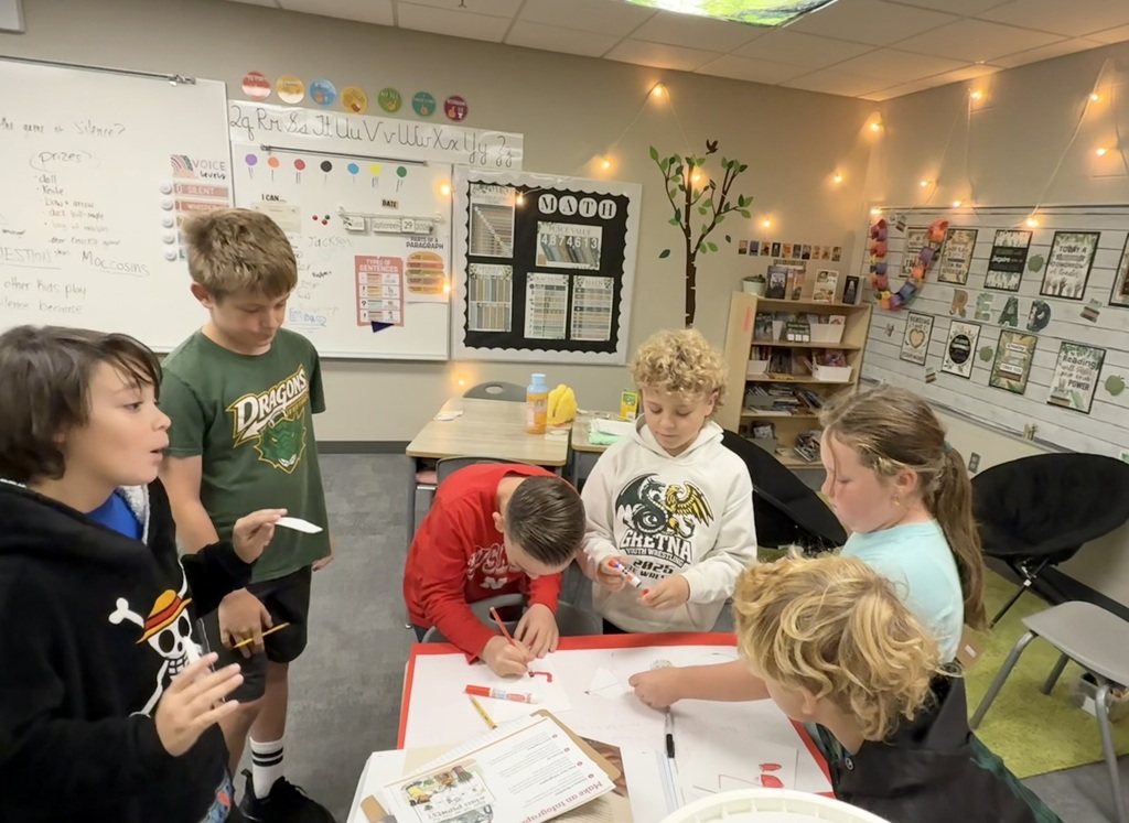 students working on a science project ina a group at a table in a classroom
