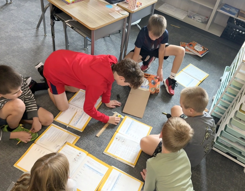 students with books on the floor working together on a project