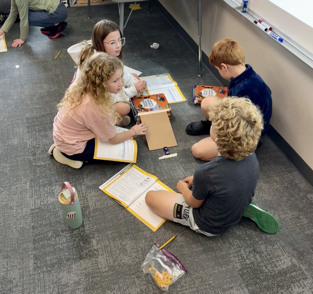 studebnts learning about and working in small groups on the floor for science