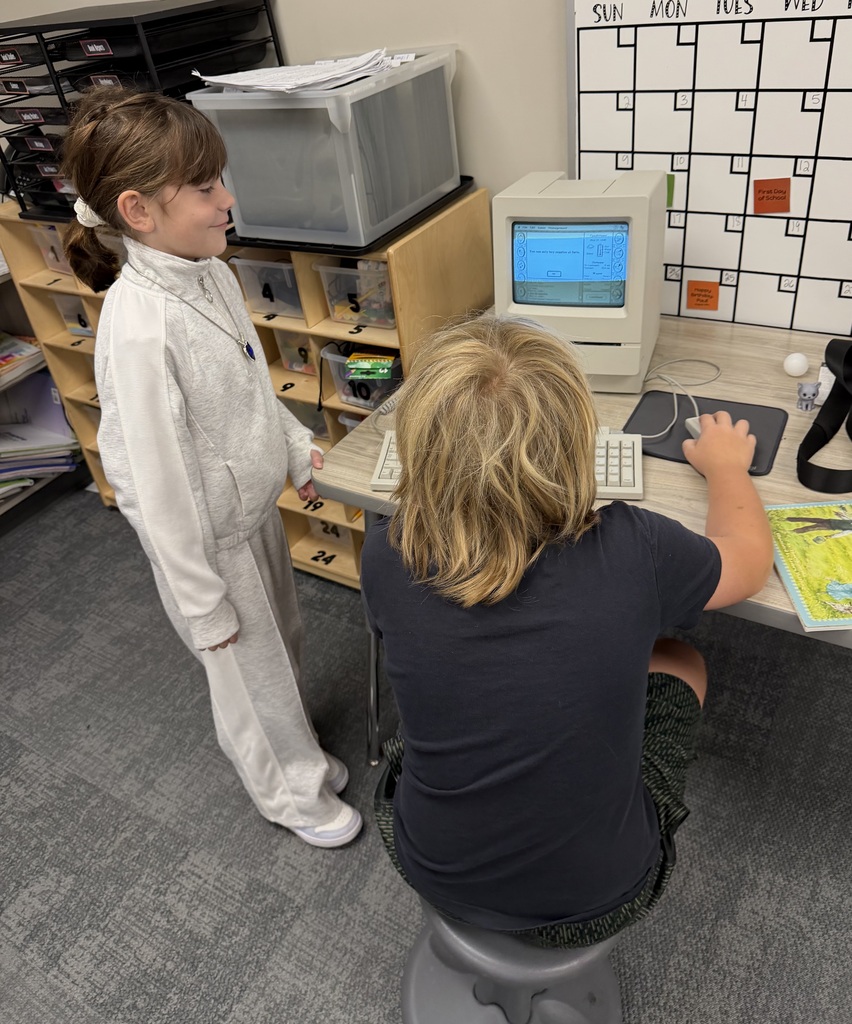 student playing on an old macintosh computer