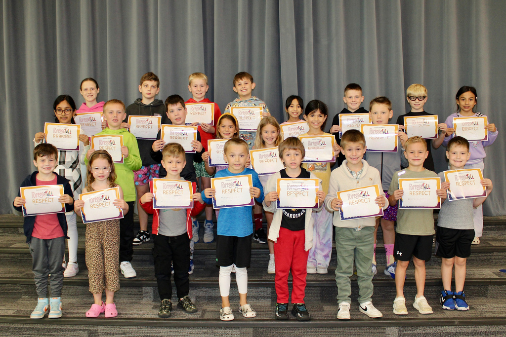 3 rows of students holding their Respect signs for Student of the month.