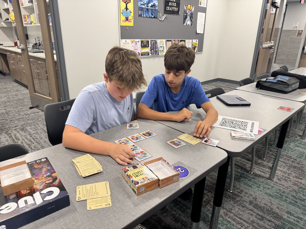 Two male students are doing a breakout puzzle game. 
