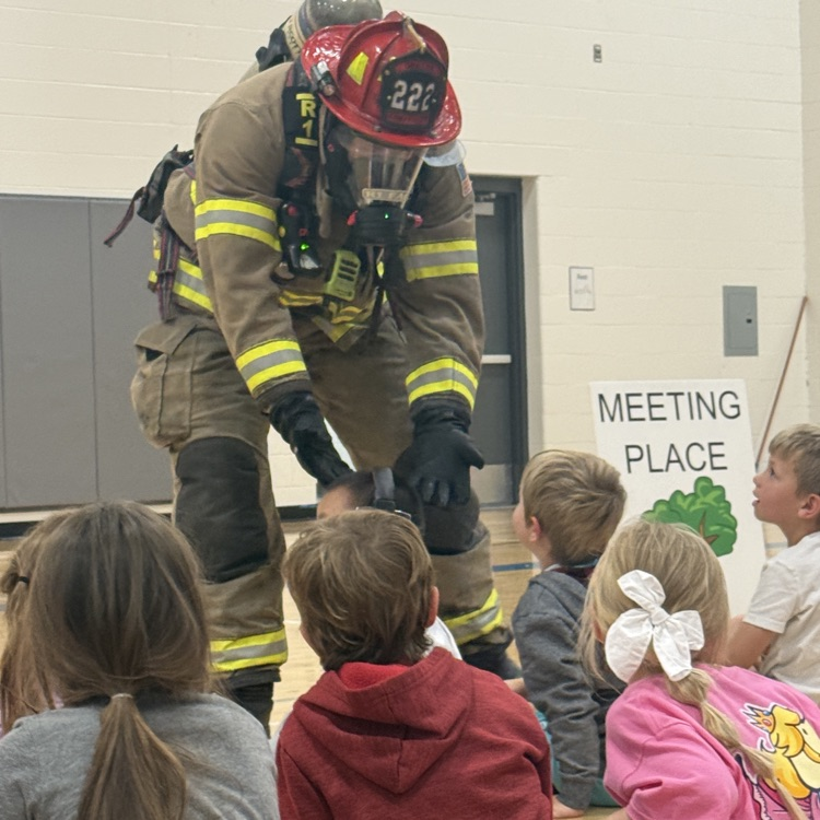 firefighter Greg gives high fives to students 