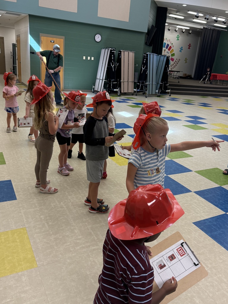 Students pointing out fire alarms and marking tallies on their clipboards