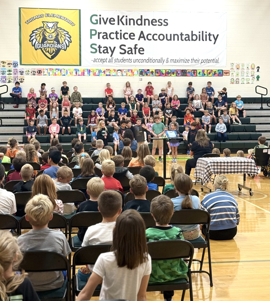 3rd grade students on the bleachers and students seated listening to the music program. 