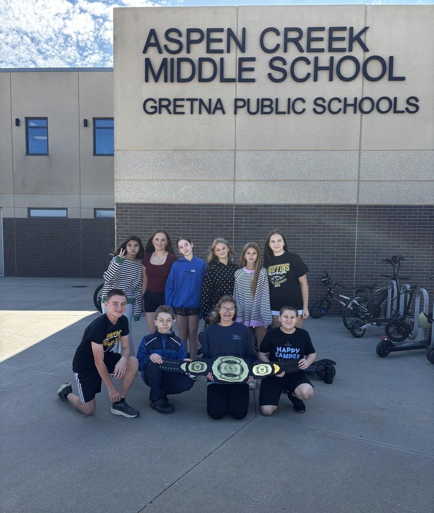 Ten students outside of ACMS posing with Win the Moment belt award