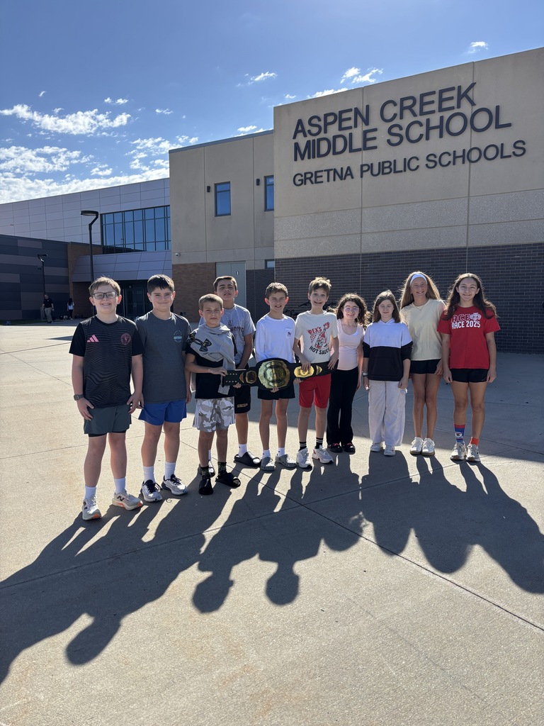 Ten students outside of ACMS posing with Win the Moment belt award