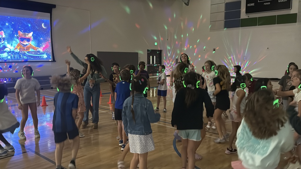 fourth graders are dancing in the gym with their silent disco headphones