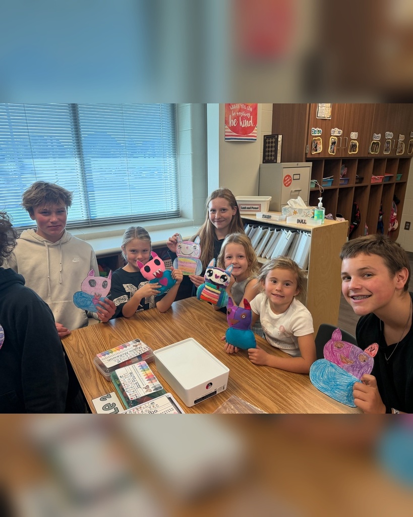 Students enjoying showing off their drawings and finished sewing projects.