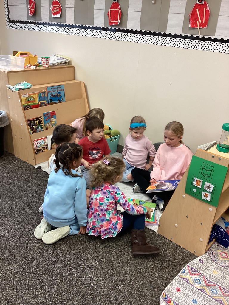 3rd grade student reading to preschool students