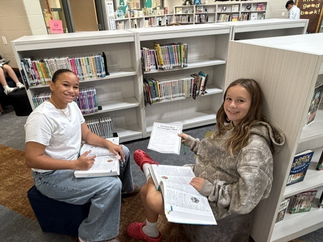 Two students working on a research project in a library class.