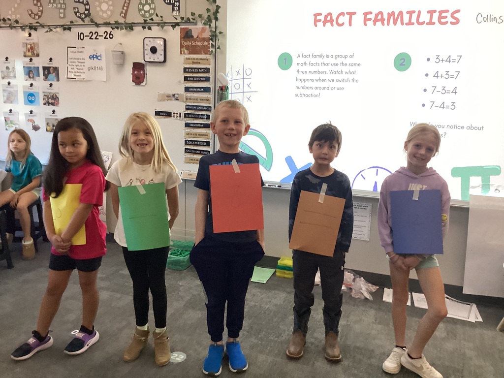 Students in Mrs. Collins' 2nd grade WIN group pose with numbers taped to their clothes for a fact family project in the classroom.