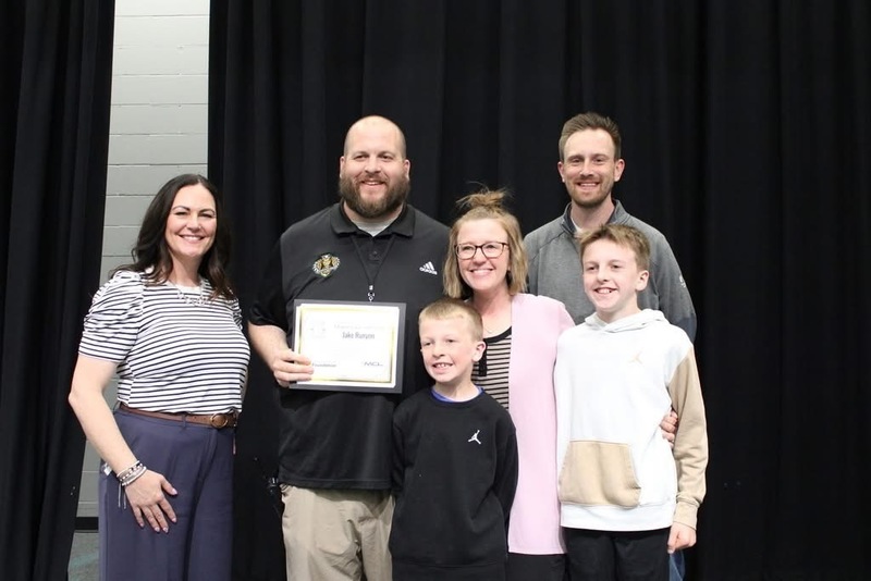 Mr. Runyon receiving an award on stage. He is standing next to representatives from the GPS foundation, MCL, and his wife and two sons.