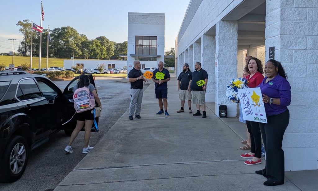 volunteers greeting students