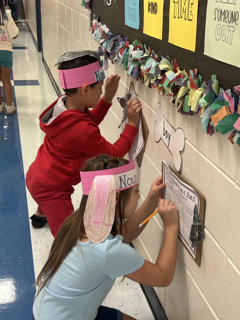 students holding clipboards, writing at walls