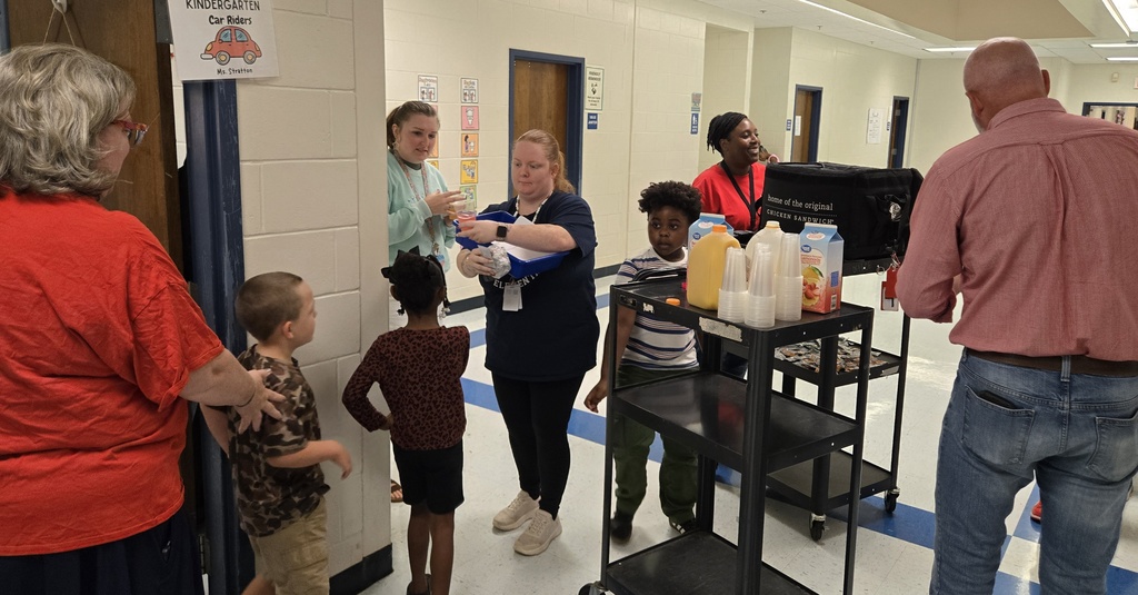 several teachers receiving biscuits from carts