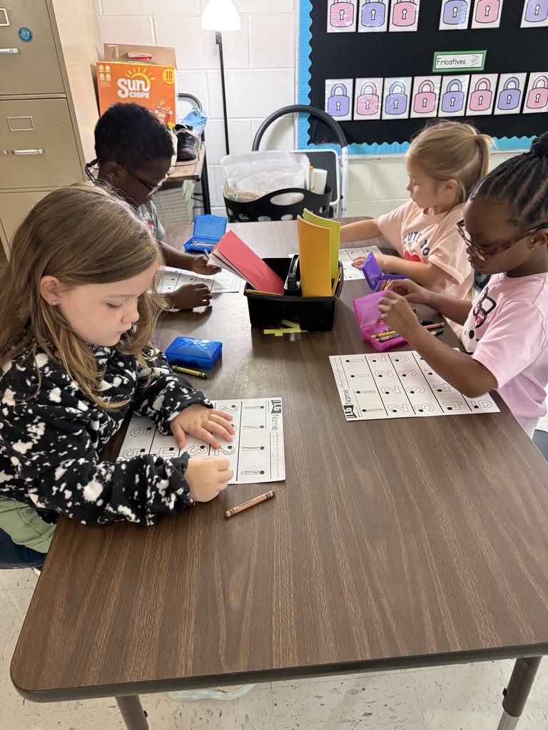students at tables wriing with crayons