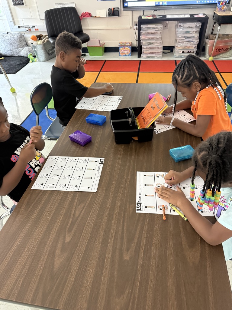 students at tables wriing with crayons