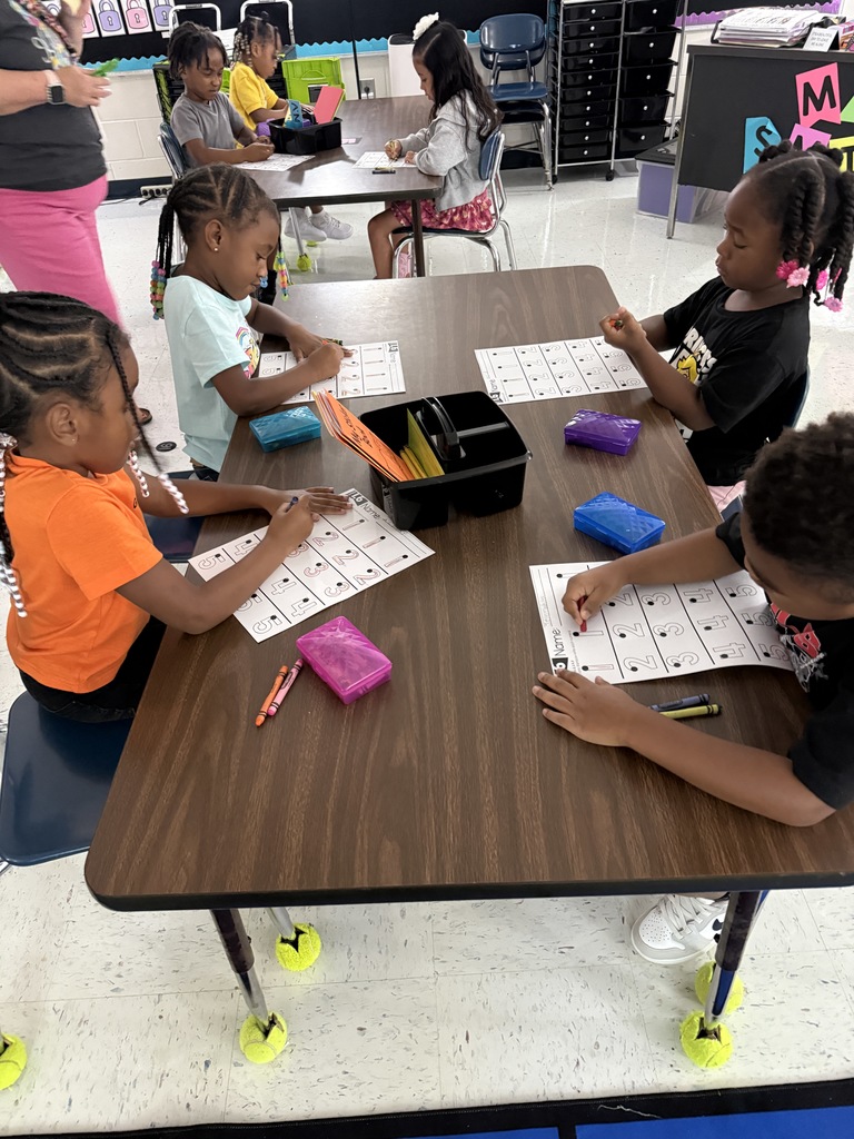 students at tables wriing with crayons