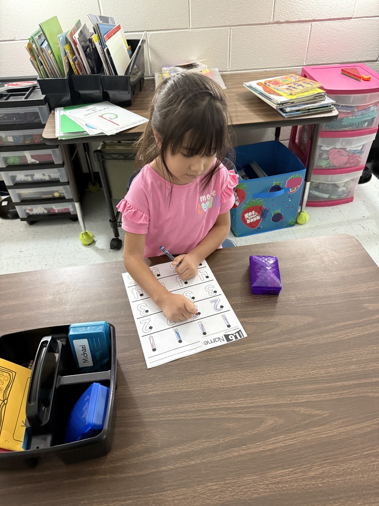 female student at table wriing with crayons