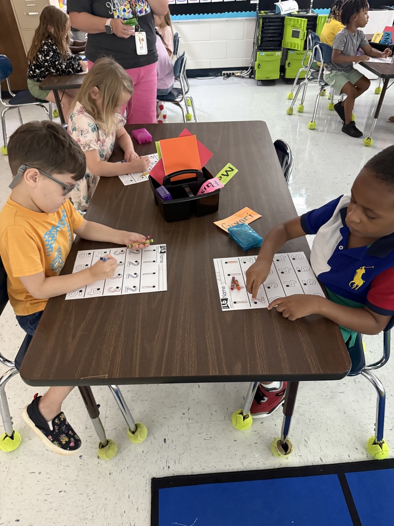 students at tables wriing with crayons