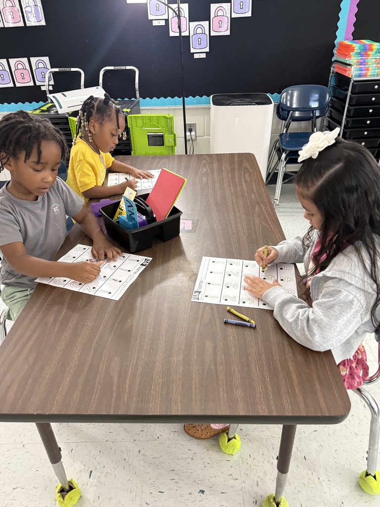 students at tables wriing with crayons