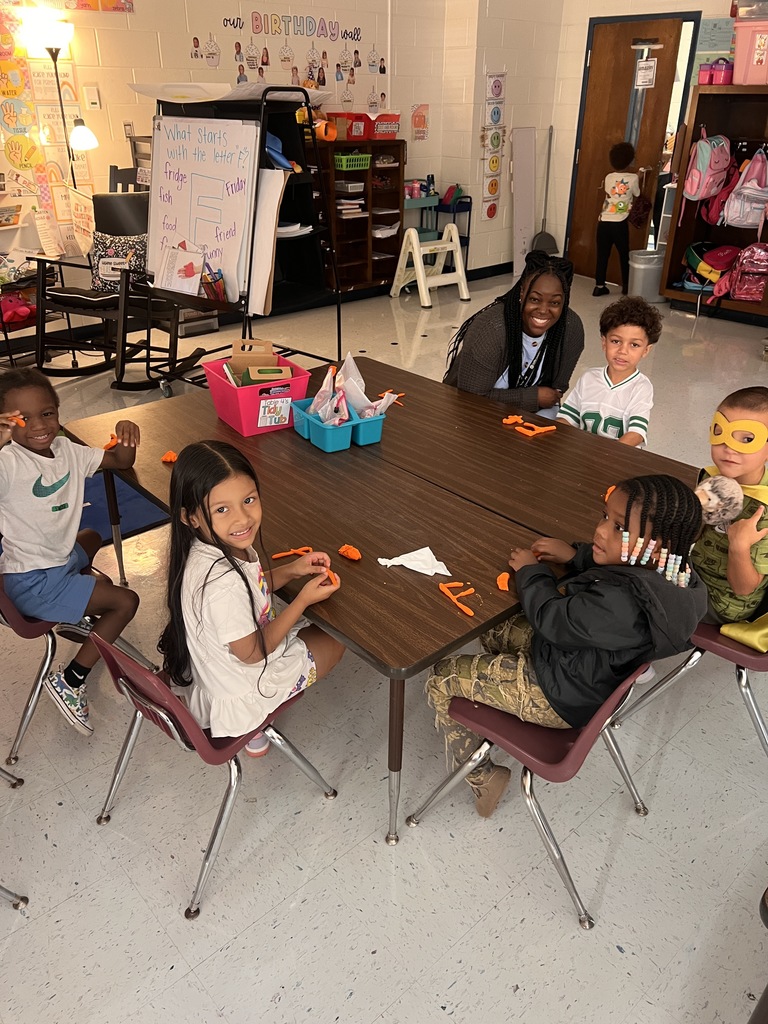 students working at table with play-dough, making letters.