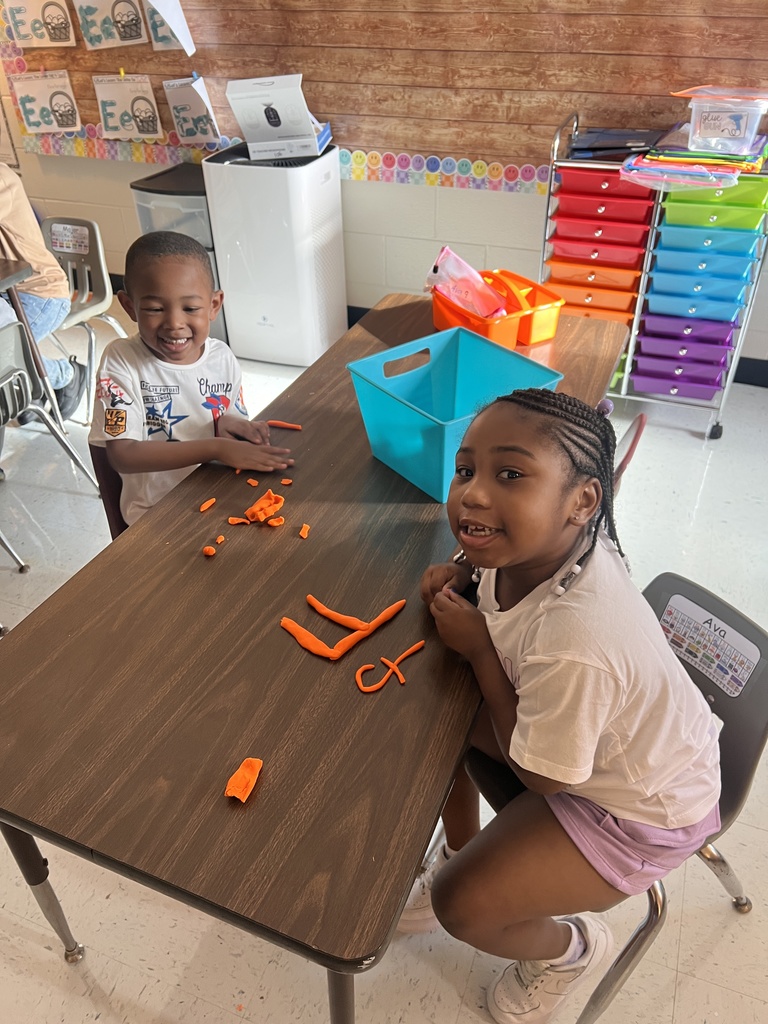 students working at table with play-dough, making letters.