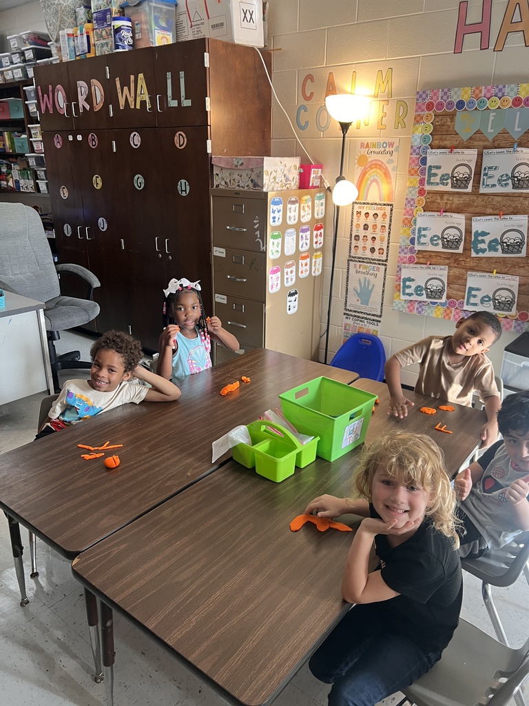 students working at table with play-dough, making letters.