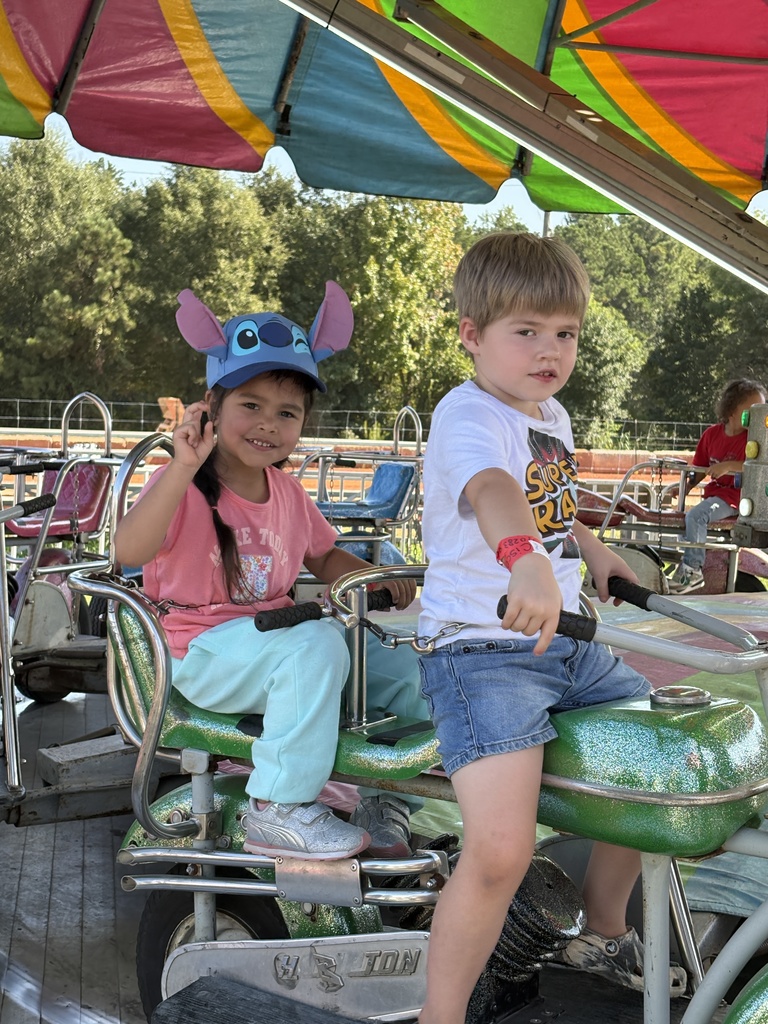 girl and boy on "motorcyle" on a carousel