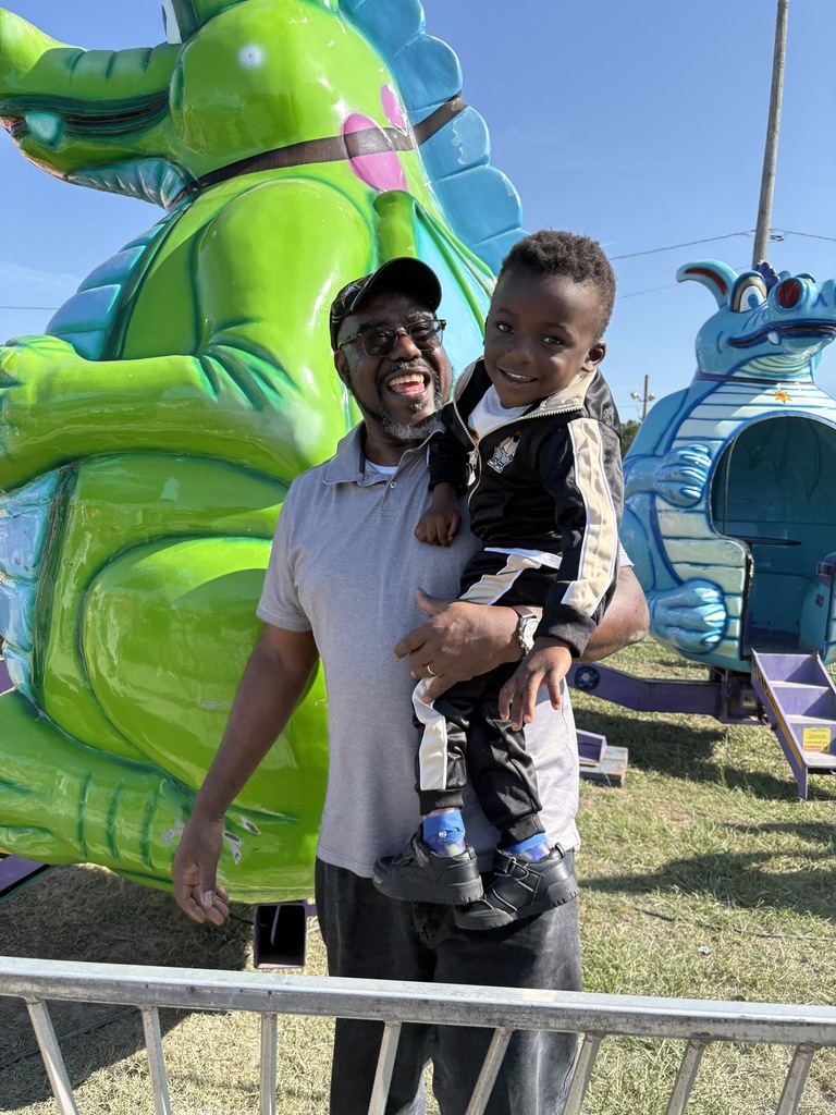 man holding young boy at fair