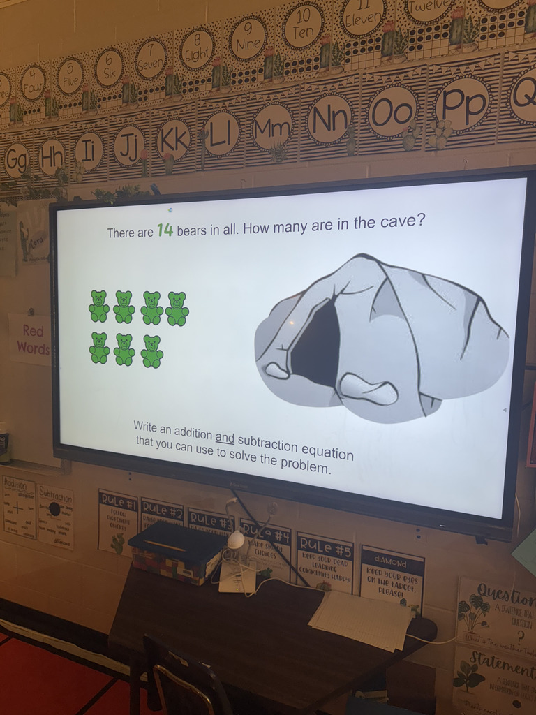 class ClearTouch panel showing math problem: "There are 14 bears in all. How many are in the cave?" 7 green gummy bears showing with pic of cave