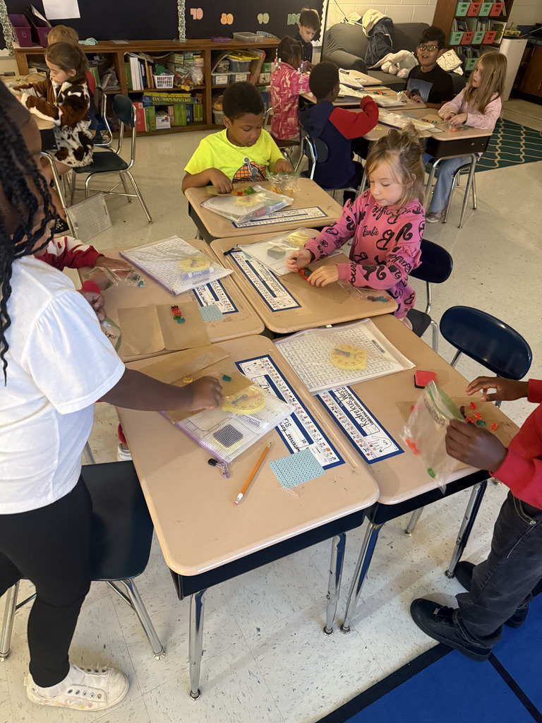 kids at desks with gummy bears, writing math equations