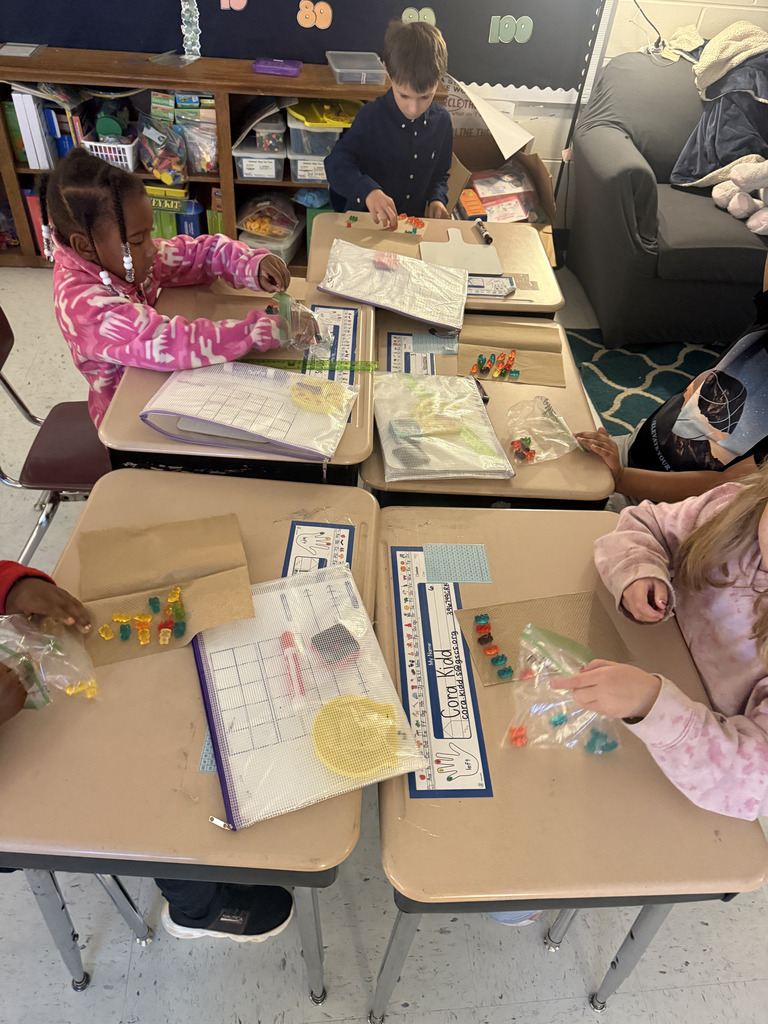 kids at desks with gummy bears, writing math equations