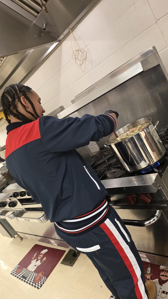 A student stirs vegetable stock while cooking