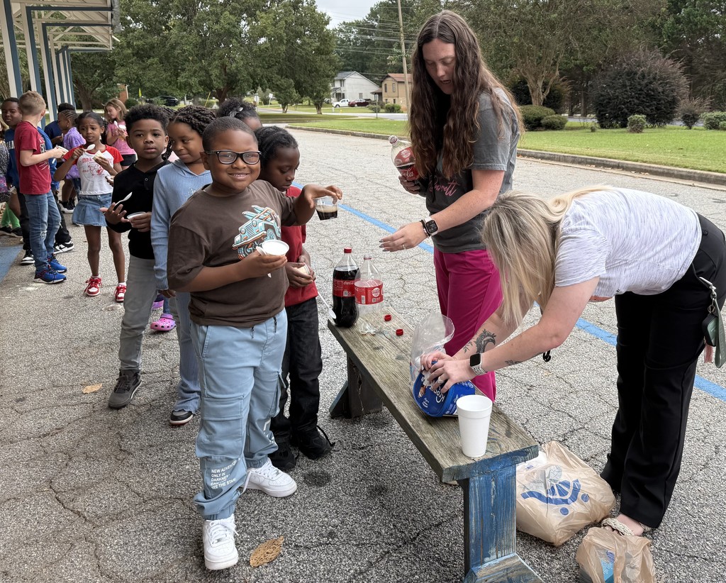 group of kids outside on sidewalk, eating coke floats