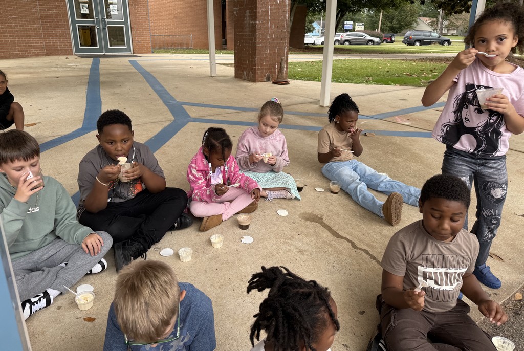 group of kids outside on sidewalk, eating coke floats