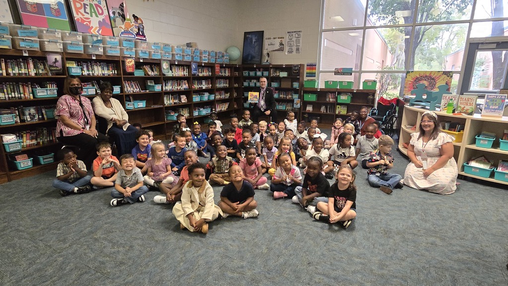 group pic of PreK classes with reader in back holding a book