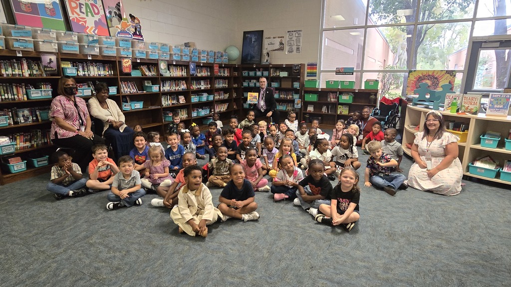 group pic of PreK classes with reader in back holding a book