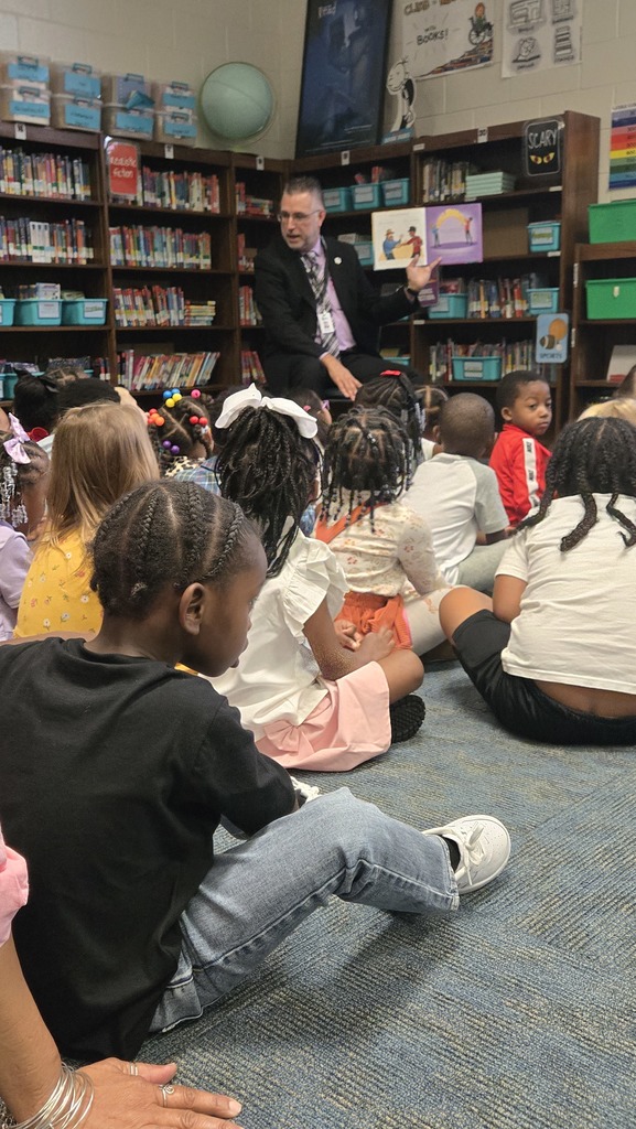 man reading in front of small children