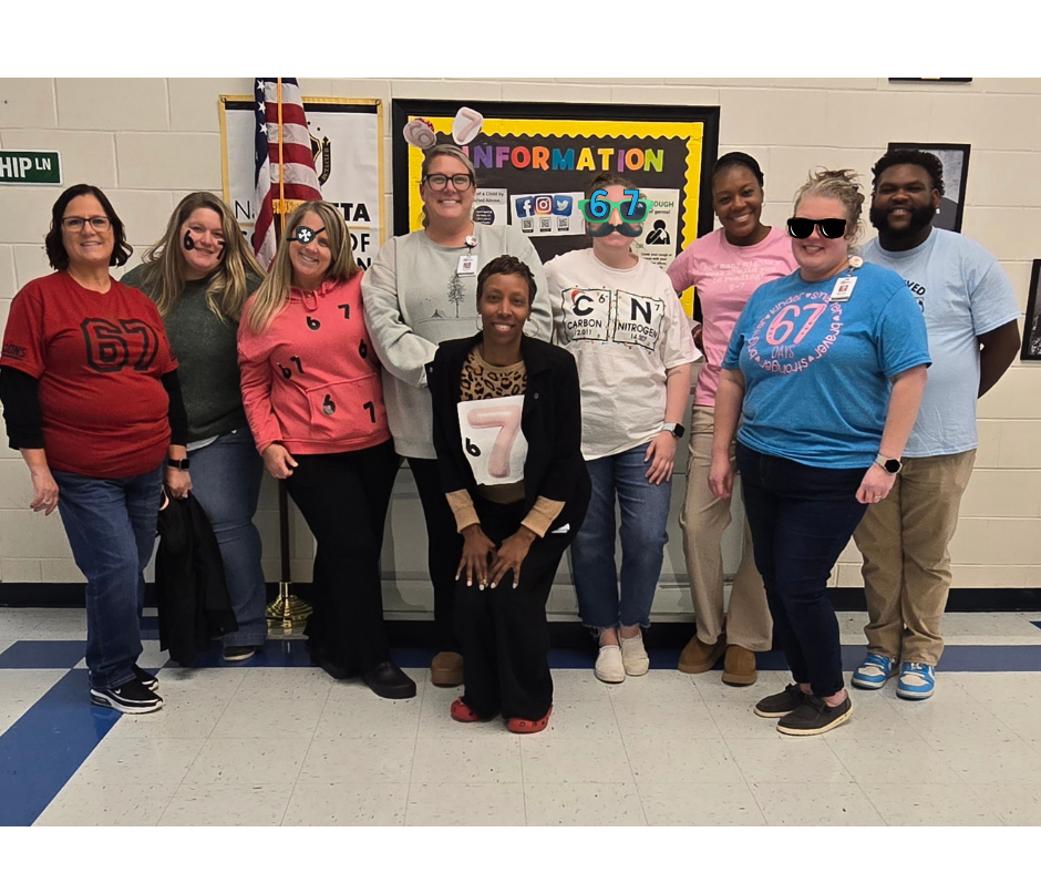 teachers in hall with 67 shirts and headgear
