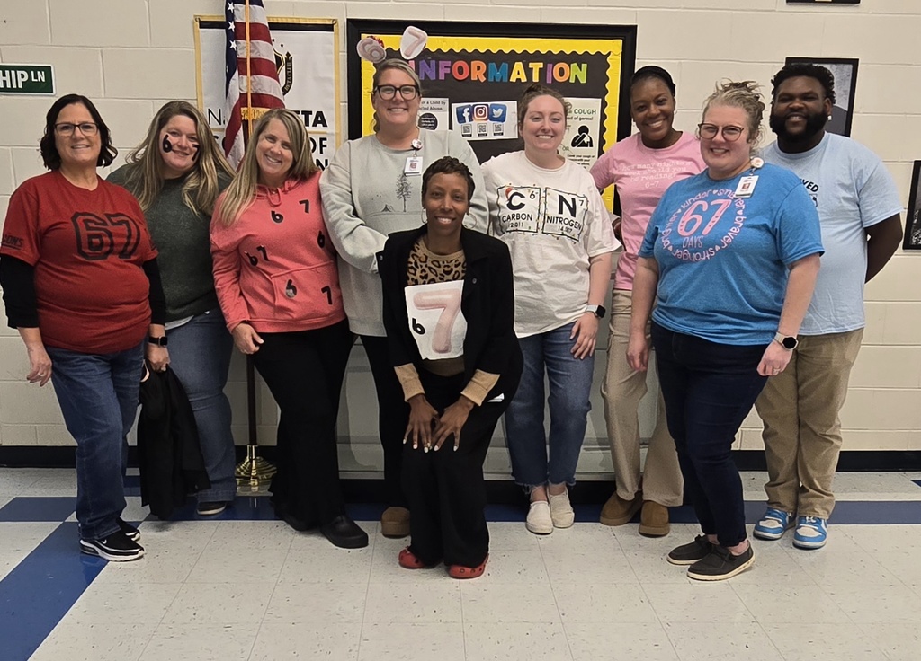 teachers in hall with 67 shirts and headgear