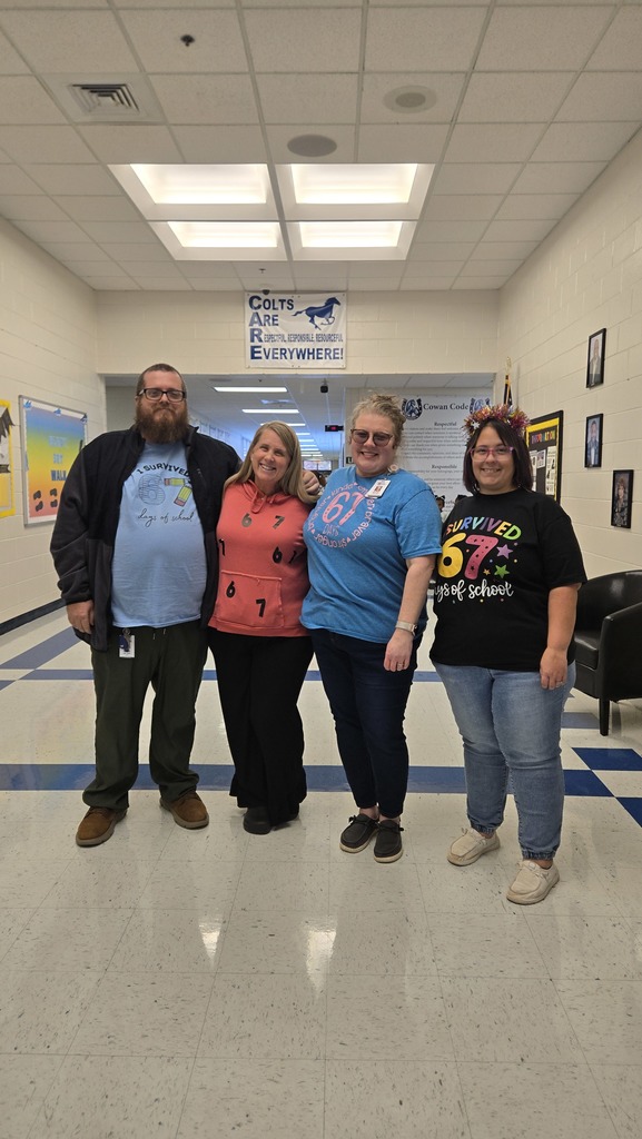 teachers in hall with 67 shirts
