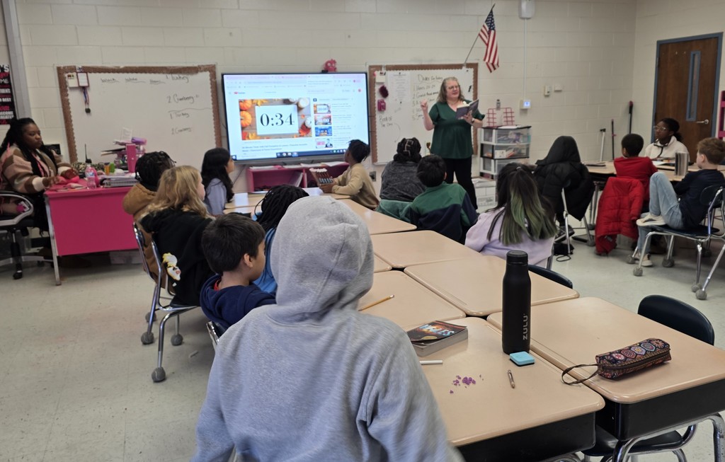adult reading in front of class of young children
