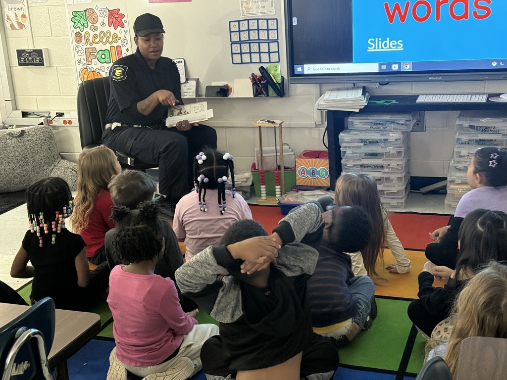 adult reading in front of class of young children