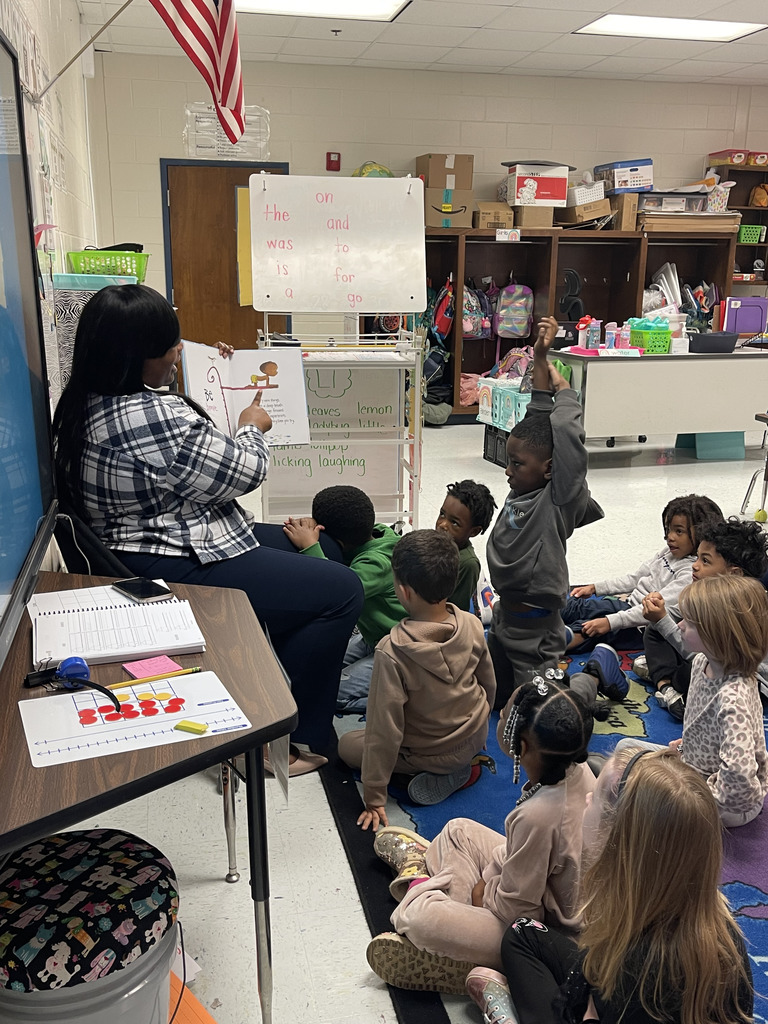 adult reading in front of class of young children