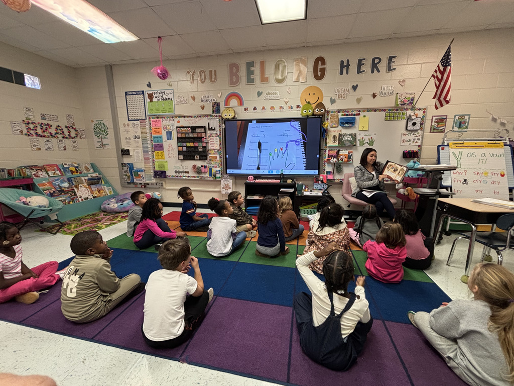 adult reading in front of class of young children