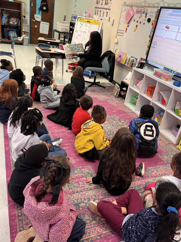 adult reading in front of class of young children