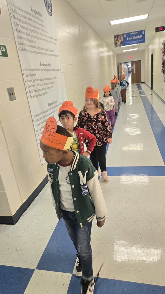 kids in hall lined up, wearing turkey hats
